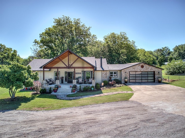 32188 E 738th Rd, Wagoner, OK 74467 - view of front of home featuring covered porch, concrete driveway, a front yard, a garage, and stone siding
