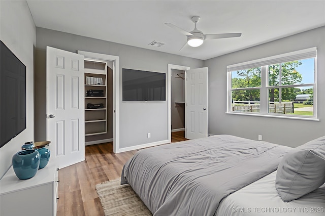 245 E 148th St S, Glenpool, OK 74033 - bedroom with a spacious closet, wood finished floors, a closet, ceiling fan, and baseboards