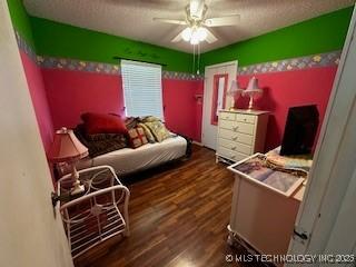 1408 11th NW, Ardmore, OK 73401 - bedroom featuring wood finished floors, a textured ceiling, and a ceiling fan