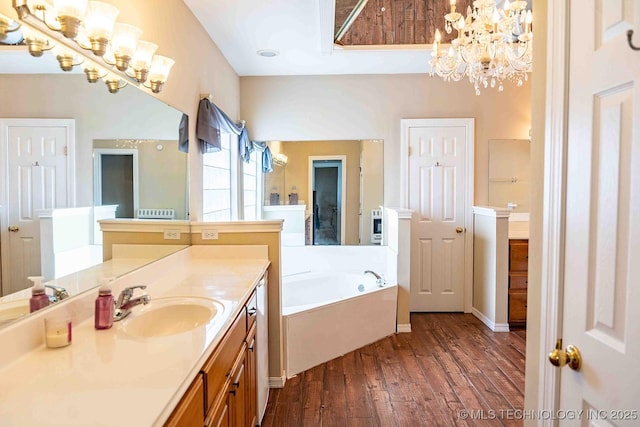 210 S Water St, Sapulpa, OK 74066 - bathroom with a chandelier, wood finished floors, vanity, and a garden tub