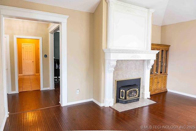 210 S Water St, Sapulpa, OK 74066 - unfurnished living room featuring a wood stove, hardwood / wood-style floors, and baseboards