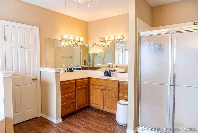 210 S Water St, Sapulpa, OK 74066 - full bath featuring wood finished floors, a stall shower, vanity, and a chandelier