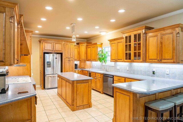 210 S Water St, Sapulpa, OK 74066 - kitchen featuring appliances with stainless steel finishes, ornamental molding, a peninsula, backsplash, and glass insert cabinets