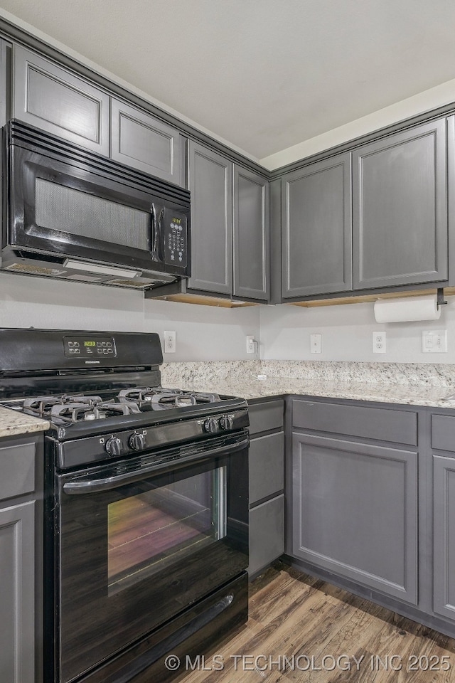 5976 E 147th St S, Bixby, OK 74008 - kitchen with black appliances, gray cabinetry, wood finished floors, and light stone counters