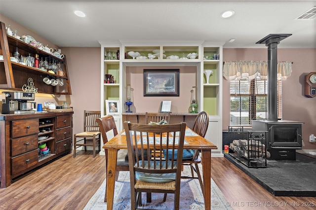 6472 Kings Rd, Ardmore, OK 73401 - dining room featuring a wood stove, wood finished floors, and recessed lighting