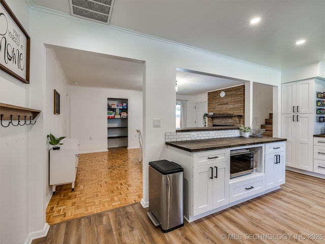 1518 E 58th St, Tulsa, OK 74105 - kitchen featuring butcher block counters, white cabinets, crown molding, recessed lighting, and baseboards