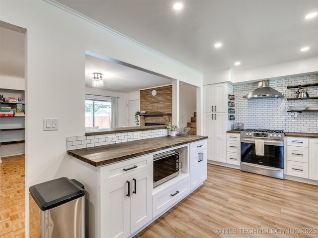 1518 E 58th St, Tulsa, OK 74105 - kitchen with stainless steel range with gas cooktop, wooden counters, wall chimney range hood, backsplash, and recessed lighting