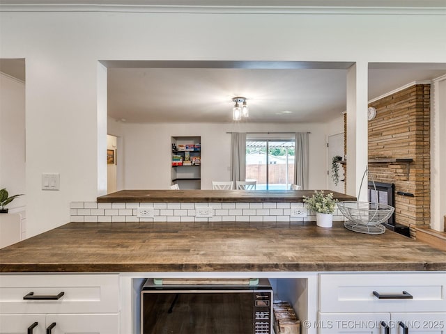 1518 E 58th St, Tulsa, OK 74105 - kitchen featuring wine cooler, a brick fireplace, and white cabinets