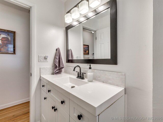 1518 E 58th St, Tulsa, OK 74105 - bathroom with vanity, tasteful backsplash, wood finished floors, and baseboards