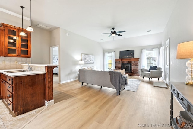 4701 S 179th E Ave, Tulsa, OK 74134 - living area with ceiling fan, light wood-type flooring, a brick fireplace, and baseboards