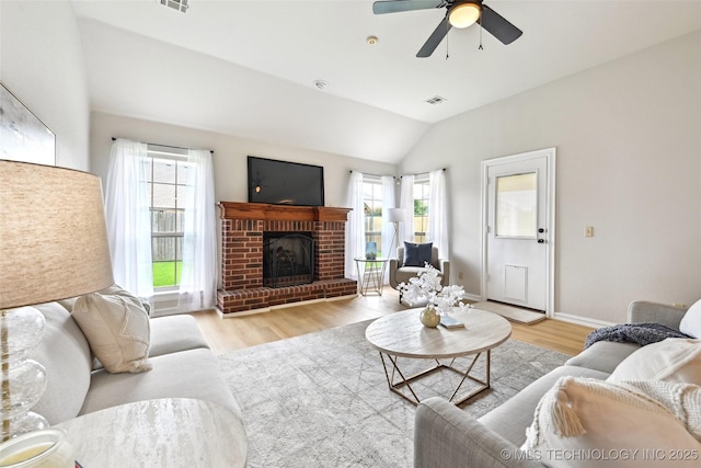 4701 S 179th E Ave, Tulsa, OK 74134 - living area with healthy amount of natural light, light wood finished floors, vaulted ceiling, a brick fireplace, and ceiling fan