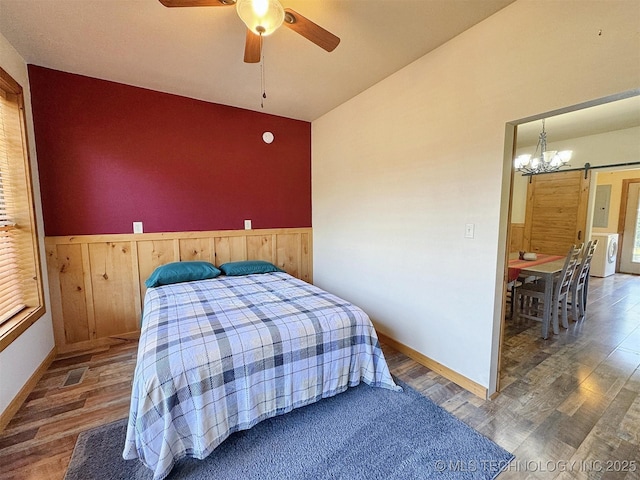 20413 E Allen Rd, Tahlequah, OK 74464 - bedroom with vaulted ceiling, wood finished floors, washer / clothes dryer, a wainscoted wall, and a chandelier