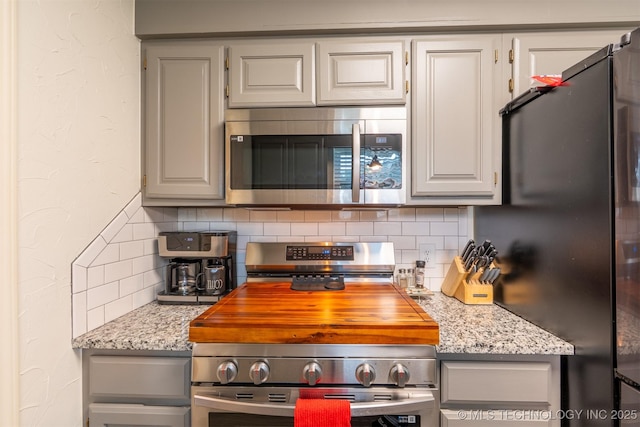 20903 E 35th St S, Broken Arrow, OK 74014 - kitchen with stainless steel appliances, tasteful backsplash, gray cabinetry, and light stone counters