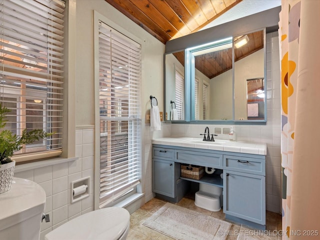 2310 Skyline Dr, Bartlesville, OK 74006 - bathroom with toilet, wood ceiling, tile walls, lofted ceiling, and plenty of natural light