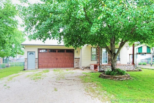 410 Shawnee St, So Coffeyville, OK 74072 - view of property hidden behind natural elements with stone siding, an attached garage, and driveway