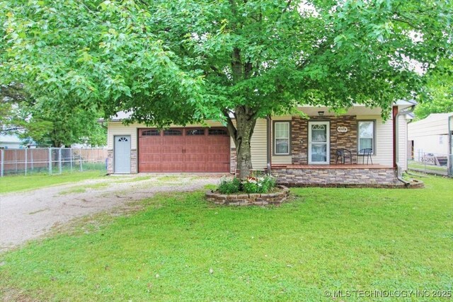 410 Shawnee St, So Coffeyville, OK 74072 - view of front of property with dirt driveway, stone siding, a porch, and a garage
