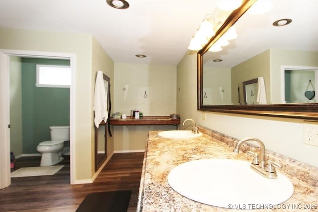 410 Shawnee St, So Coffeyville, OK 74072 - full bath with toilet, double vanity, wood finished floors, baseboards, and recessed lighting