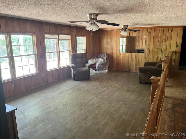 98 Whispering Pines Ln, Stigler, OK 74462 - sitting room featuring a textured ceiling, wooden walls, ceiling fan, and wood finished floors