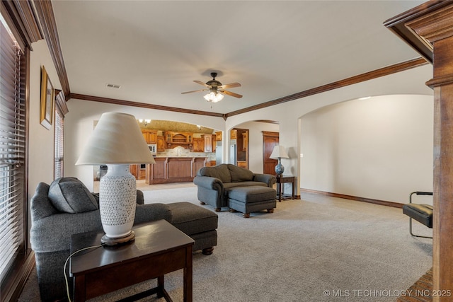 6601 E 85th St, Owasso, OK 74055 - living area with arched walkways, a ceiling fan, crown molding, light colored carpet, and baseboards