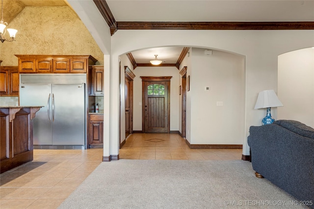 6601 E 85th St, Owasso, OK 74055 - foyer with ornamental molding, light tile patterned floors, arched walkways, baseboards, and light colored carpet