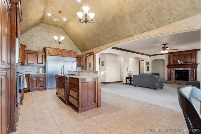 6601 E 85th St, Owasso, OK 74055 - kitchen with a chandelier, arched walkways, ceiling fan, light tile patterned flooring, and high vaulted ceiling
