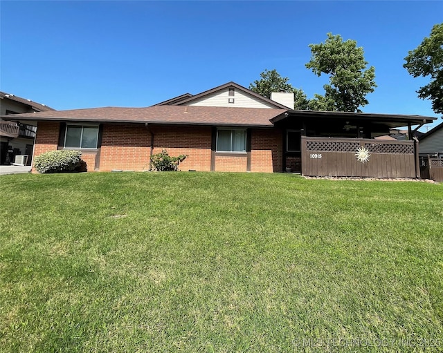 10915 E 11th Pl Unit 08-1D, Tulsa, OK 74128 - ranch-style house featuring brick siding, a front lawn, a chimney, and roof with shingles