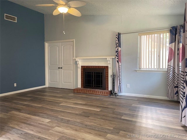10915 E 11th Pl Unit 08-1D, Tulsa, OK 74128 - unfurnished living room with lofted ceiling, a ceiling fan, wood finished floors, a textured ceiling, and a fireplace