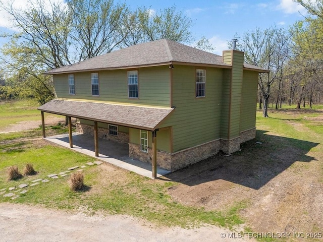 9012 S 49th W Ave, Tulsa, OK 74131 - view of property exterior with a chimney, stone siding, a patio, a shingled roof, and driveway