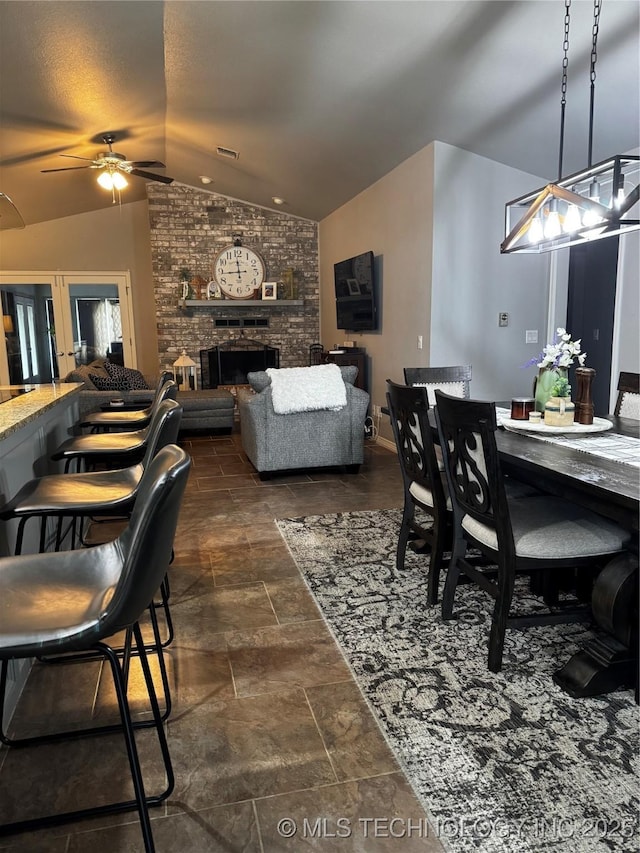 1105 Ono Ct, Mcalester, OK 74501 - dining area featuring lofted ceiling, a ceiling fan, a brick fireplace, and dark stone finish floors