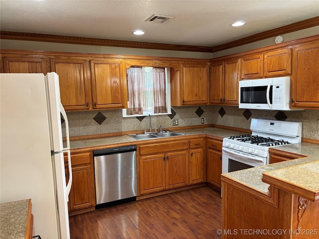 9412 S 55th St, Muskogee, OK 74403 - kitchen featuring white appliances, a sink, brown cabinets, wood finished floors, and decorative backsplash
