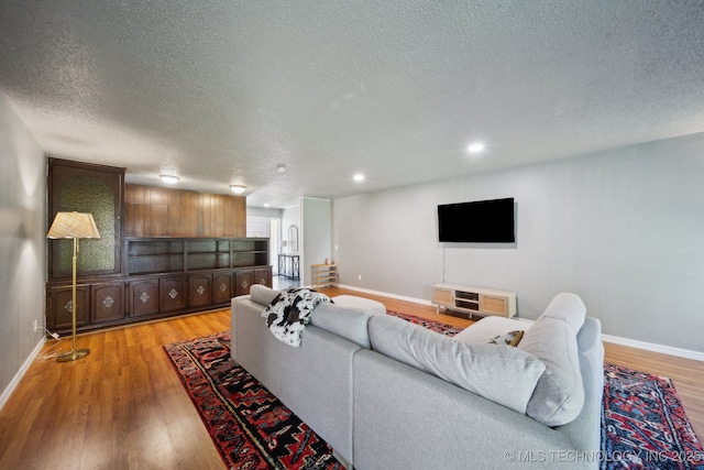 6960 S Oswego Ave, Tulsa, OK 74136 - living room with baseboards, light wood-type flooring, a textured ceiling, and recessed lighting
