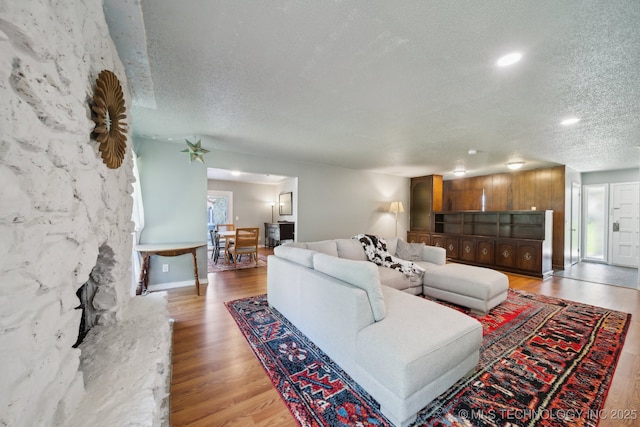 6960 S Oswego Ave, Tulsa, OK 74136 - living area featuring a textured ceiling, light wood-style floors, baseboards, and recessed lighting