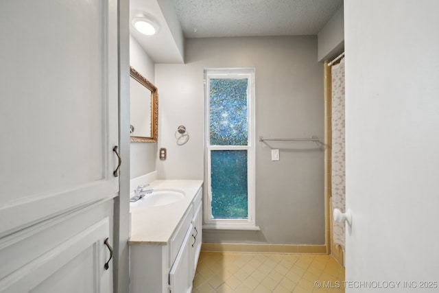 6960 S Oswego Ave, Tulsa, OK 74136 - bathroom featuring vanity, tile patterned flooring, a textured ceiling, and baseboards