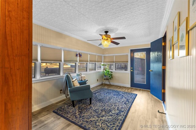 722 E 18th St, Ada, OK 74820 - sitting room featuring wood finished floors, a ceiling fan, an ornate ceiling, crown molding, and baseboards