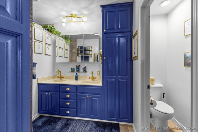 722 E 18th St, Ada, OK 74820 - full bath featuring double vanity, toilet, baseboards, and wood finished floors