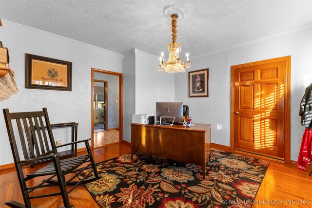 722 E 18th St, Ada, OK 74820 - home office with crown molding, wood finished floors, a textured ceiling, a chandelier, and baseboards
