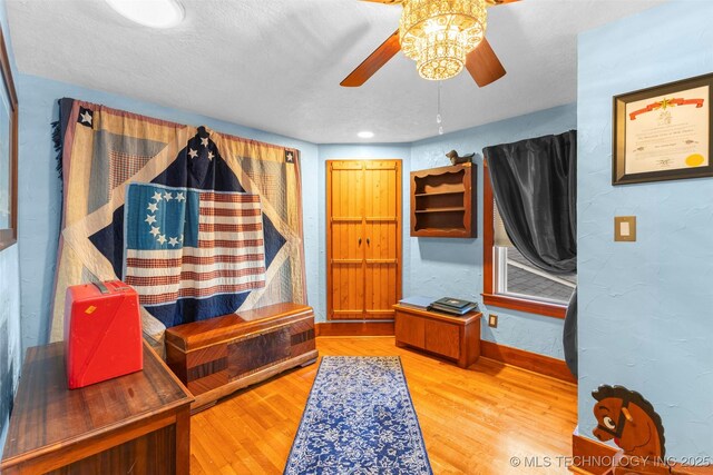 722 E 18th St, Ada, OK 74820 - bedroom featuring wood finished floors, baseboards, a textured wall, and ceiling fan