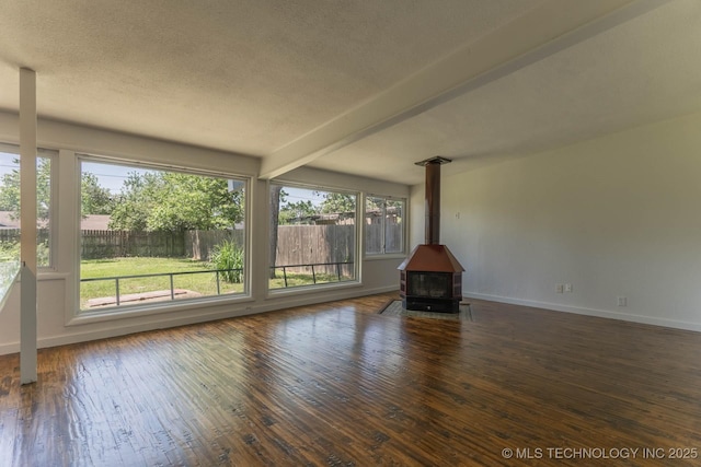 5726 E 26th St, Tulsa, OK 74114 - unfurnished living room featuring a wood stove, hardwood / wood-style flooring, baseboards, beamed ceiling, and a textured ceiling