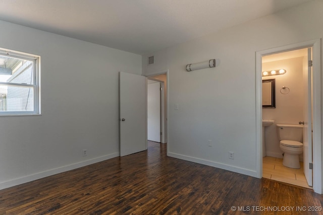 5726 E 26th St, Tulsa, OK 74114 - unfurnished bedroom with dark wood-type flooring, ensuite bathroom, and baseboards