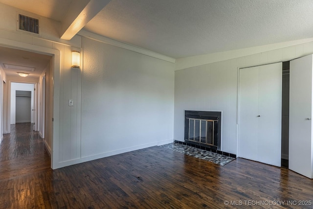 5726 E 26th St, Tulsa, OK 74114 - unfurnished living room featuring wood finished floors, a fireplace with flush hearth, beamed ceiling, a textured ceiling, and baseboards