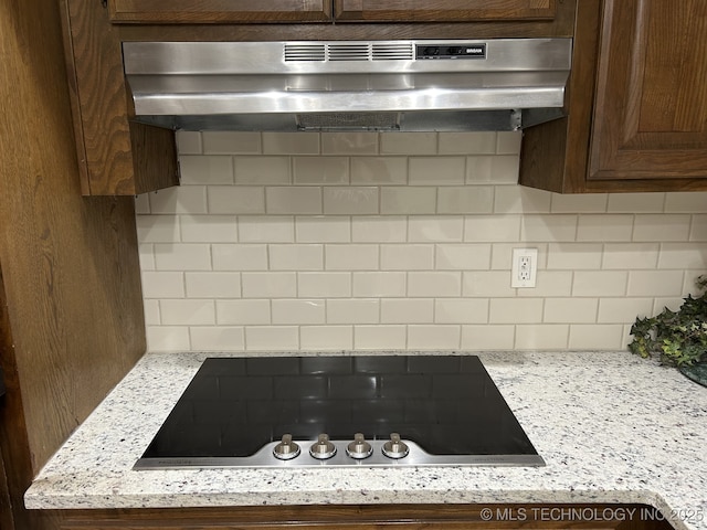 2806 E 84th St Unit 3, Tulsa, OK 74137 - kitchen view of black electric cooktop, under cabinet range hood, decorative backsplash, and dark brown cabinets