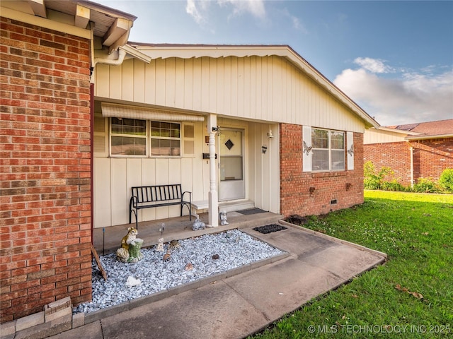 1412 S 9th, Mcalester, OK 74501 - property entrance featuring brick siding, a lawn, crawl space, and covered porch