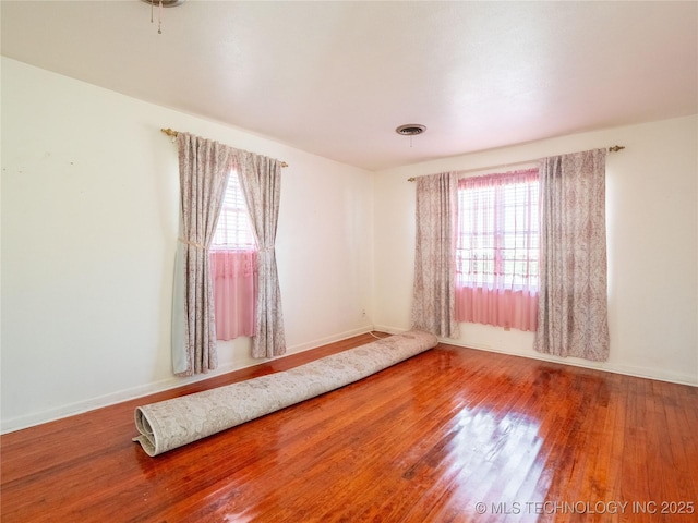 1412 S 9th, Mcalester, OK 74501 - unfurnished room with healthy amount of natural light, wood finished floors, and baseboards