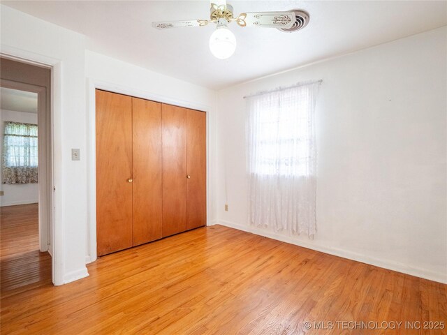 1412 S 9th, Mcalester, OK 74501 - unfurnished bedroom with light wood finished floors, a closet, baseboards, and a ceiling fan