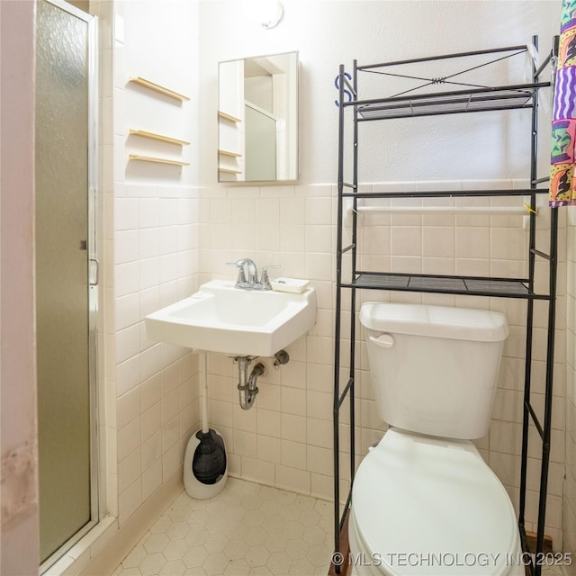 1412 S 9th, Mcalester, OK 74501 - bathroom featuring toilet, tile walls, a shower stall, wainscoting, and a sink