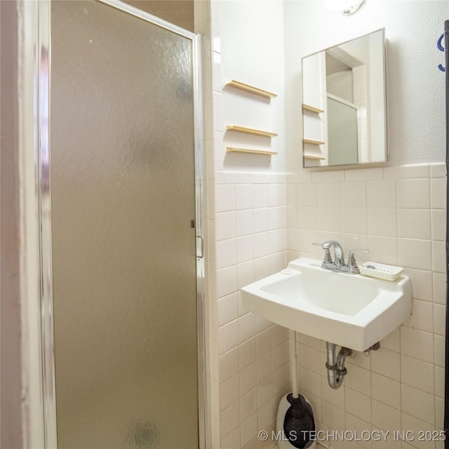 1412 S 9th, Mcalester, OK 74501 - bathroom featuring tile walls, a shower stall, a wainscoted wall, and a sink