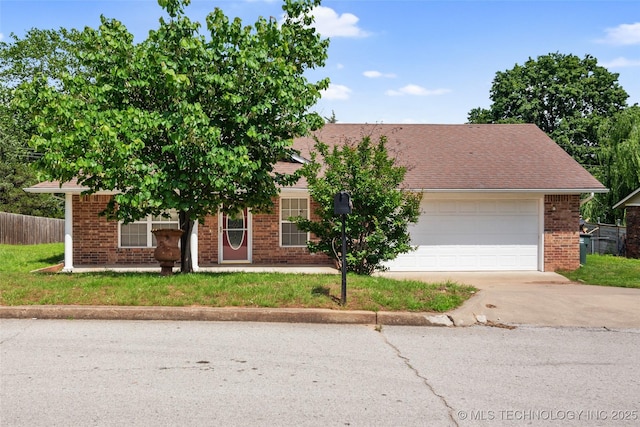 15 W Ridge Way, Bristow, OK 74010 - view of property hidden behind natural elements with concrete driveway, brick siding, and a garage