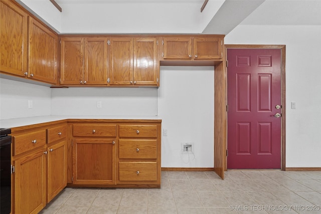 15 W Ridge Way, Bristow, OK 74010 - kitchen featuring brown cabinets, light countertops, baseboards, and light tile patterned floors