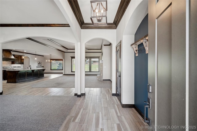 9015 N 65th E Pl, Owasso, OK 74055 - foyer with a chandelier, crown molding, arched walkways, light wood-type flooring, and baseboards