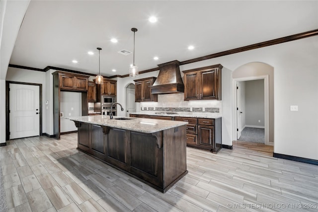 9015 N 65th E Pl, Owasso, OK 74055 - kitchen featuring arched walkways, baseboards, custom range hood, backsplash, and crown molding